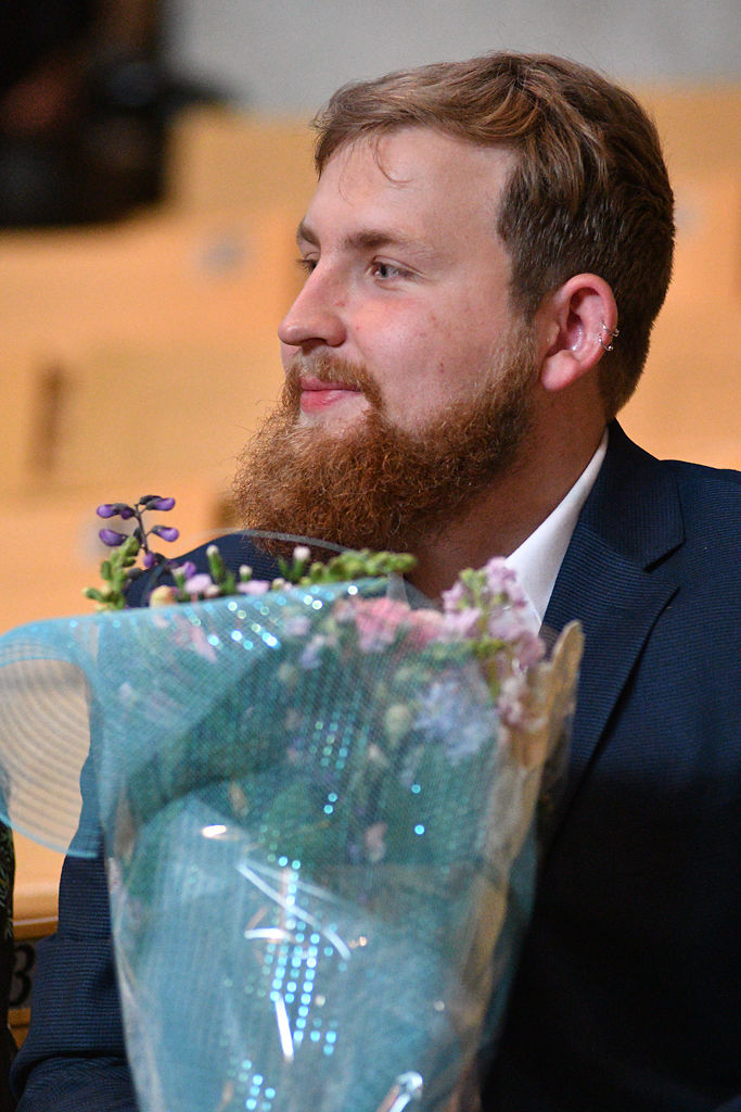 Evan O'Brien holds flowers for his girlfriend Lucy Shanker